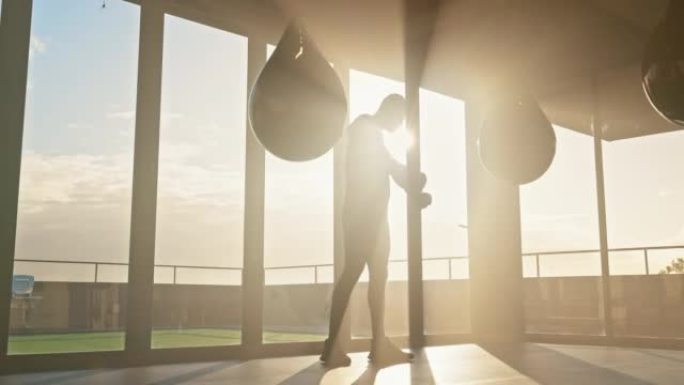 拳击手，健身和出气筒由男子在日出时在健身工作室进行锻炼，力量和训练。Mma，拳击手和体育运动员在日落