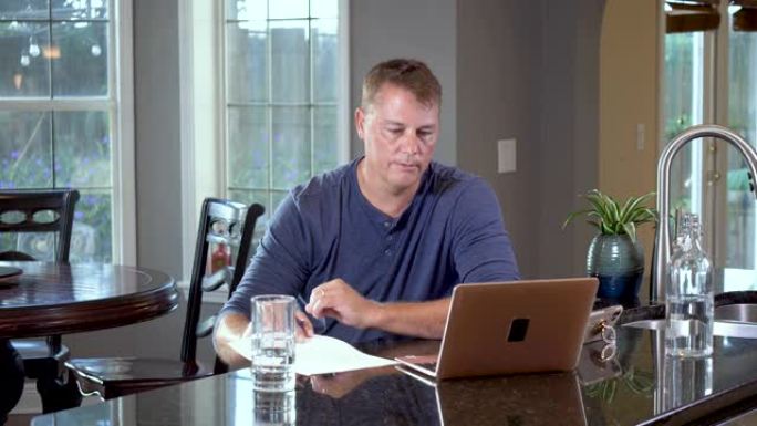 男子在家工作，使用笔记本电脑进行视频通话