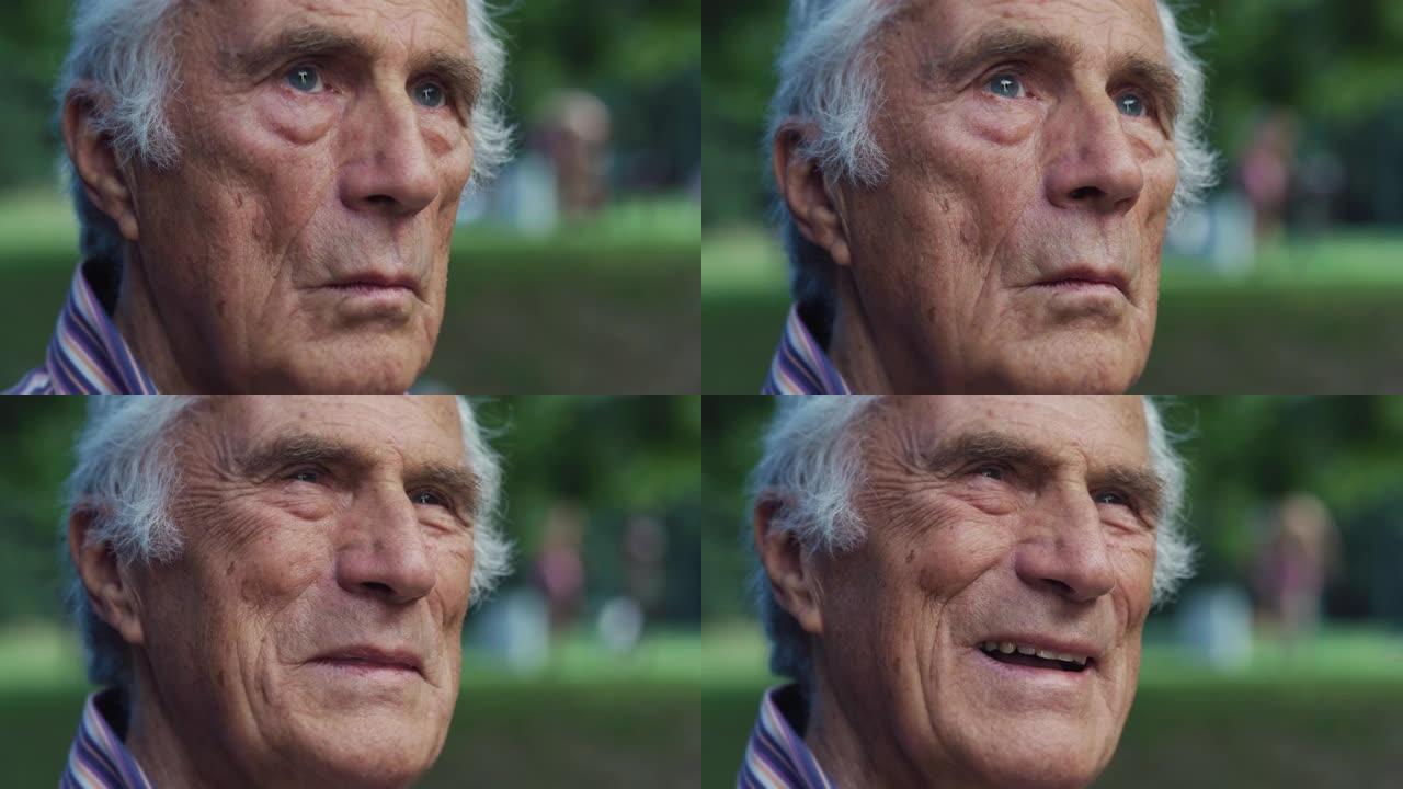 欢快的老人抬头然后在绿色公园微笑的肖像。积极积极的老年人享受夏天的天气，身体健康，生活愉快。退休男性