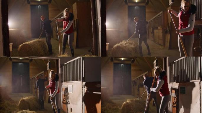 SLO MO夫妇的牧场主铲干草在马stable里喂马
