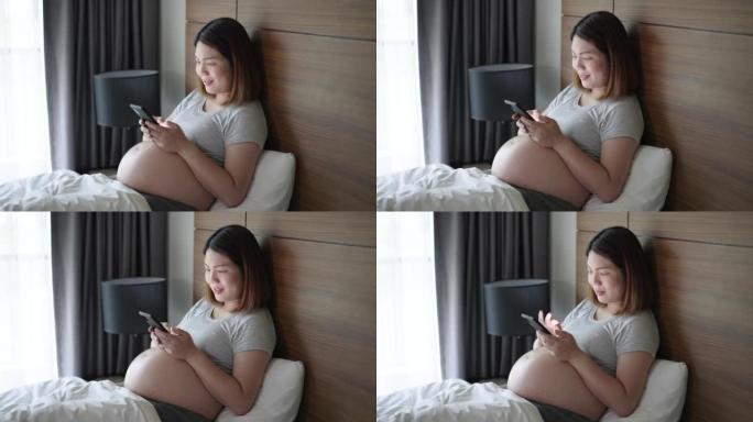 孕妇早上在卧室放松并使用手机