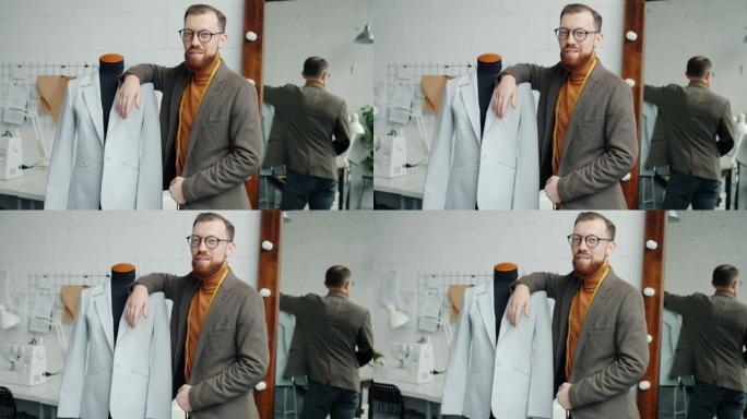 男性时装设计师的慢动作肖像站在工作室附近的假人穿着新的手工服装