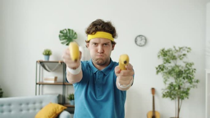 穿着复古运动服的有趣家伙看着相机用香蕉拍枪手势