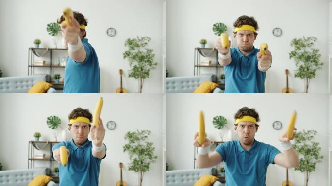 穿着复古运动服的有趣家伙看着相机用香蕉拍枪手势
