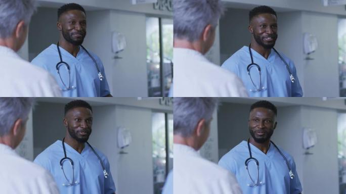 微笑的非裔美国男医生在医院工作人员会议上与不同的同事讨论