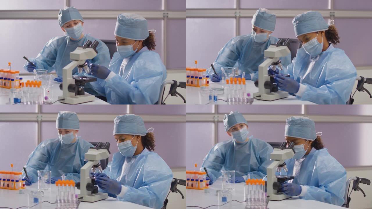 戴个人防护装备的轮椅女实验室工作人员在实验室用显微镜分析样品