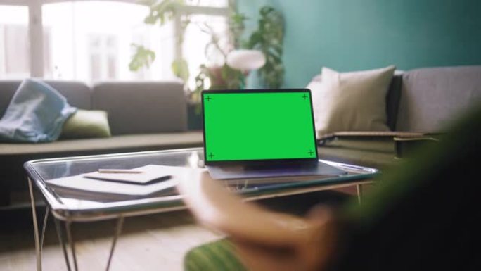 客厅桌子上的绿色屏幕笔记本电脑