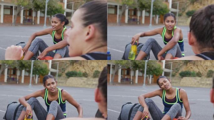 多元化的女子篮球队坐在地上聊天