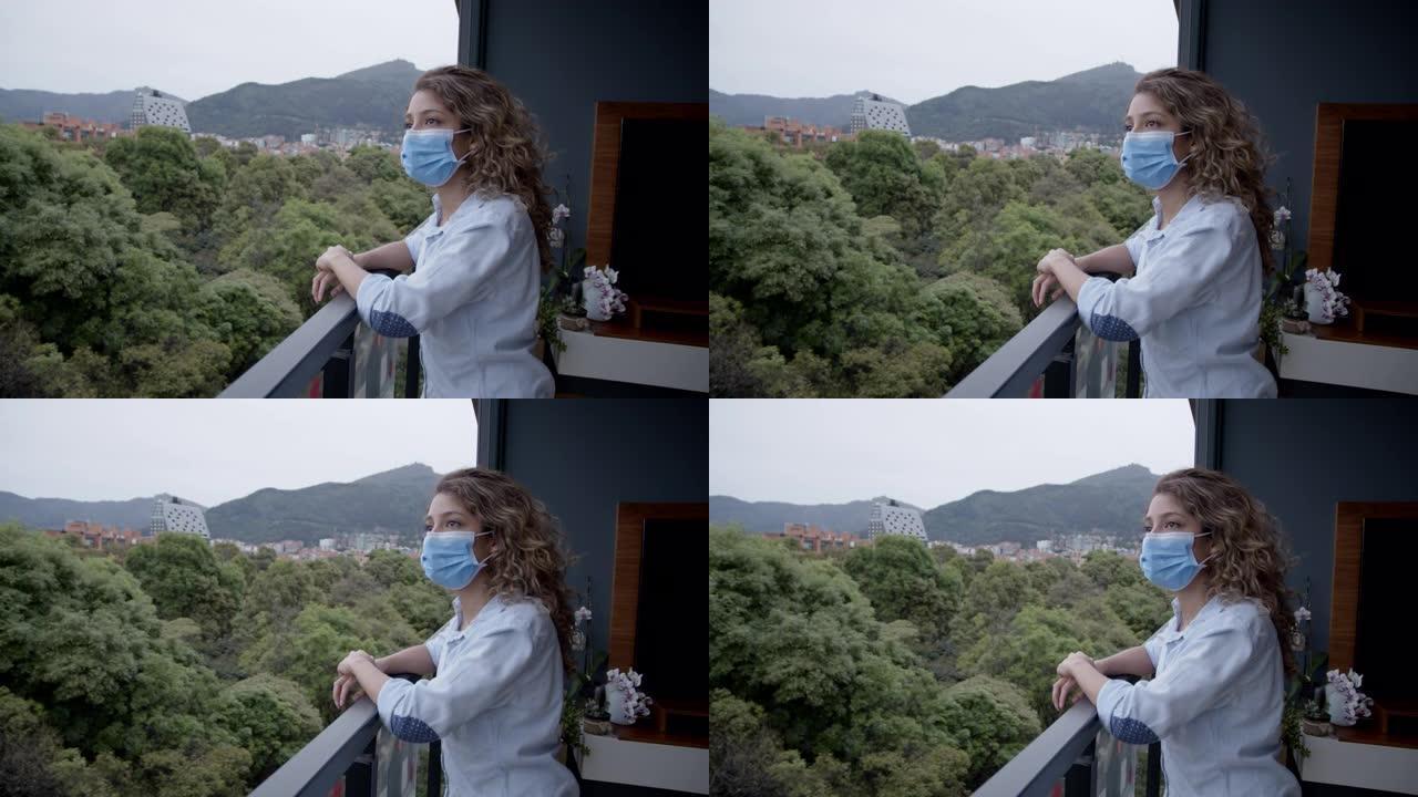 检疫的悲伤女人戴着口罩透过窗户看着风景