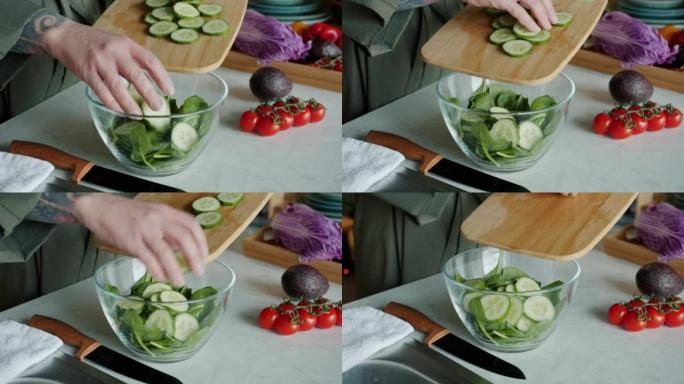 女性手的特写镜头将切成薄片的黄瓜放在家里的碗中烹饪沙拉