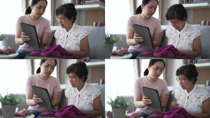 退休高级女性通过数字平板电脑与年轻女性教练一起学习面料和刺绣