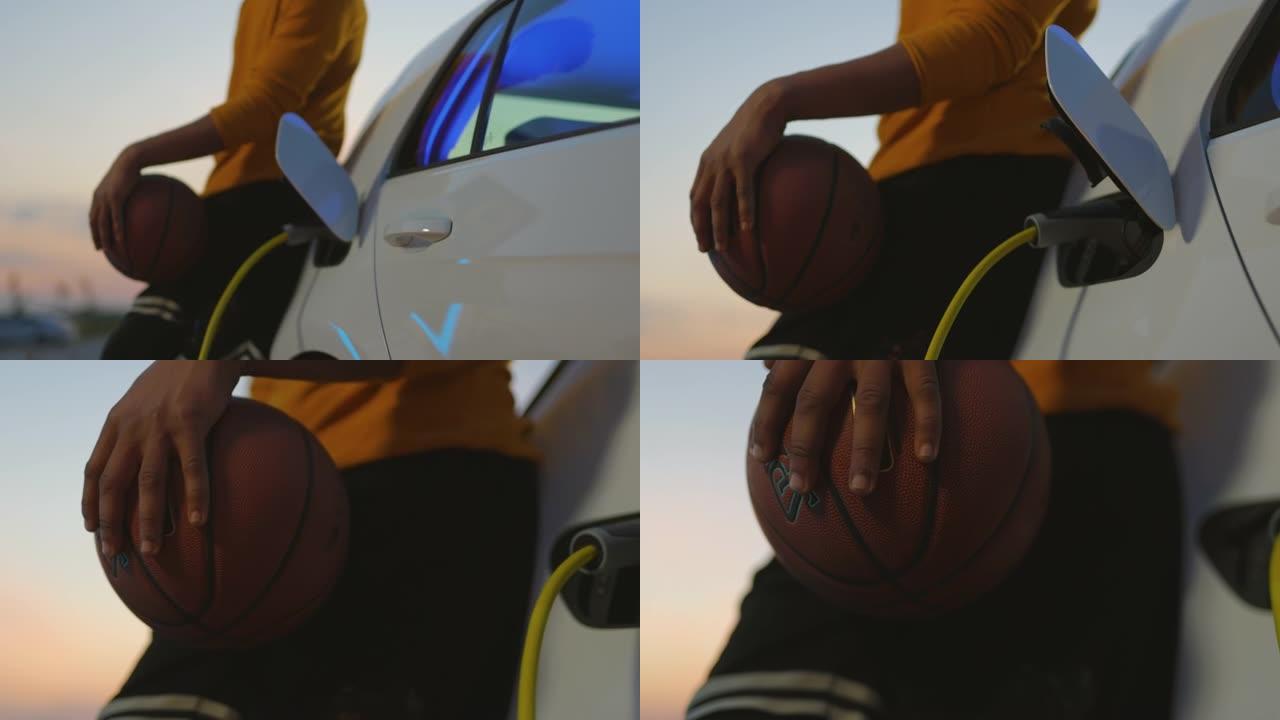 篮球运动员在停车场充电时依靠电动汽车