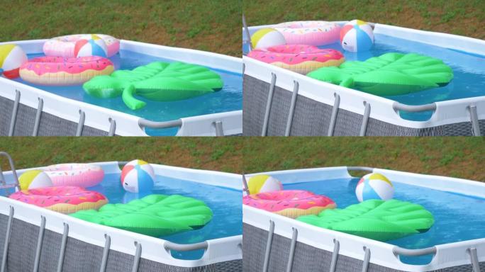 在夏季暴雨期间，后院的小游泳池充满了五颜六色的漂浮物。