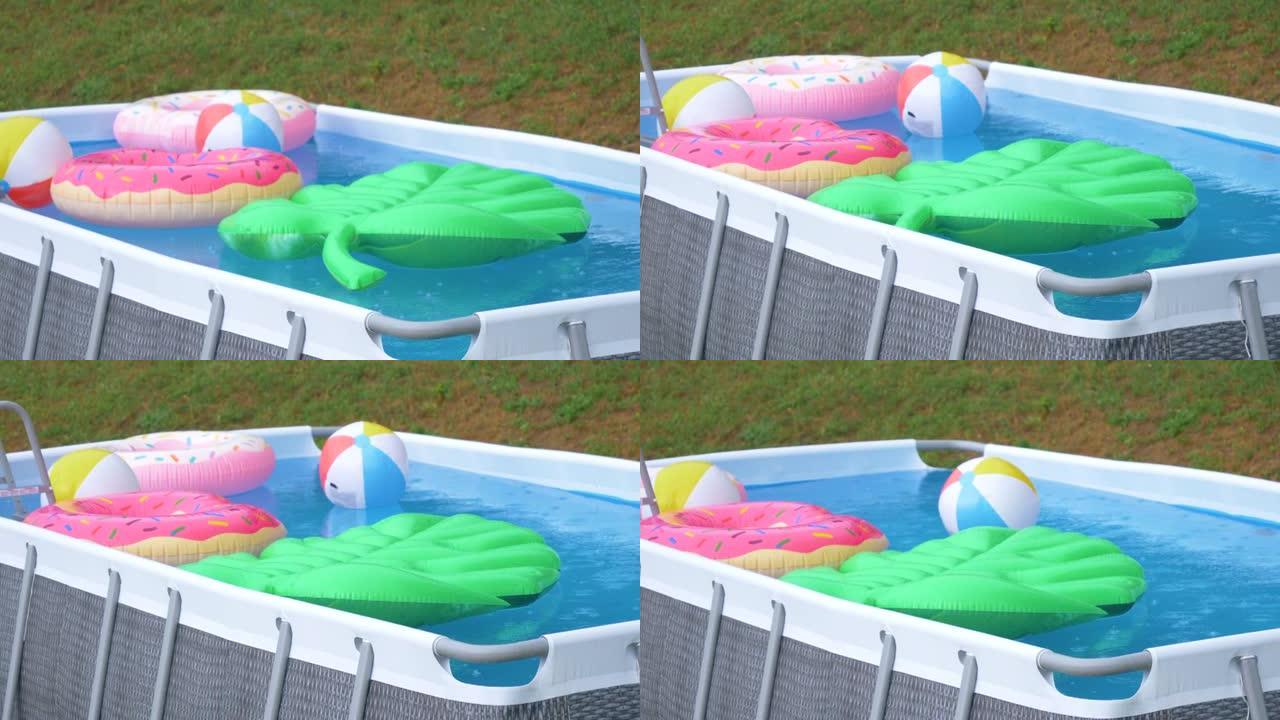 在夏季暴雨期间，后院的小游泳池充满了五颜六色的漂浮物。