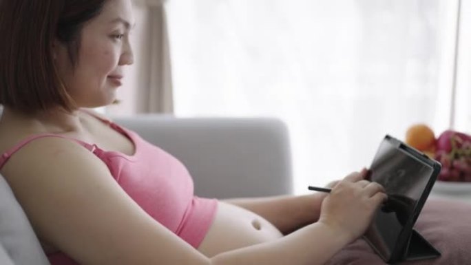 Pregnant woman using tablet in relaxing time at ho