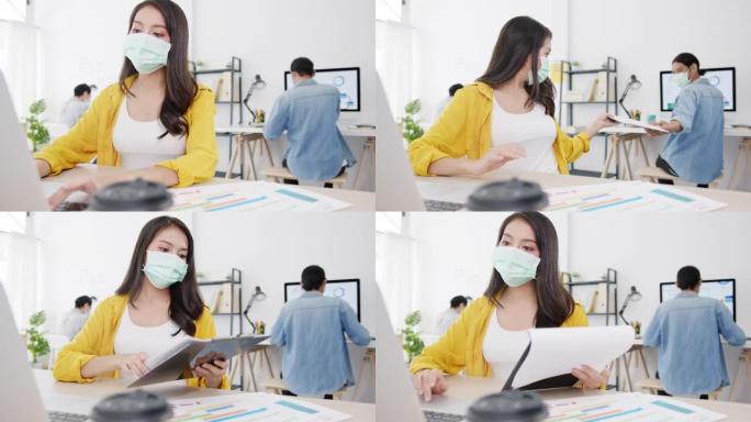 亚洲商人在新的正常情况下戴口罩以保持社交距离，以预防病毒并在办公室保持距离的情况下传递文件。