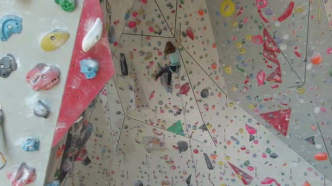 空中: 运动少年带领在攀岩健身房攀登具有挑战性的路线