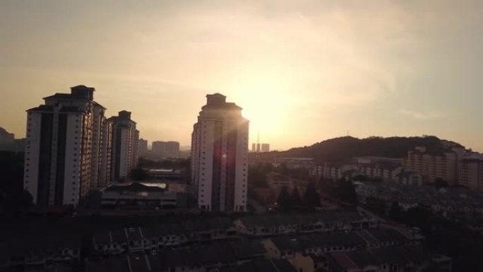 在马来西亚有公寓和相连房屋的住宅区，向上移动无人机景观日落
