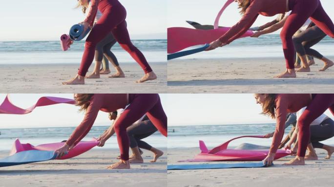 一群不同的女性朋友在海滩练习瑜伽前准备瑜伽垫