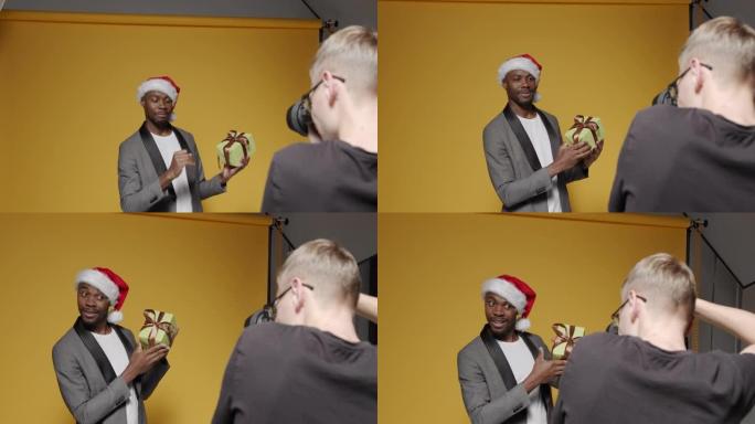 幕后拍摄一名戴着圣诞帽的黑人男子和盒装礼物