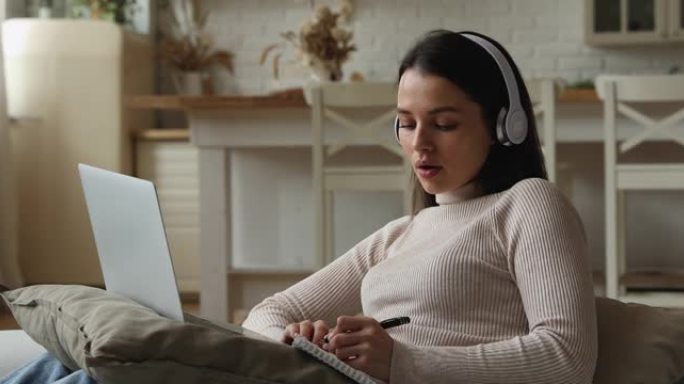 女人戴耳机电子学习远程使用电脑和视频通话