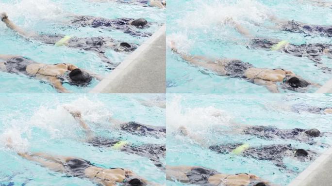 亚洲中国游泳运动员在游泳教练的指导下在游泳池边练习腿部泼水