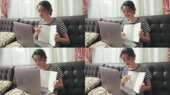 十几岁的女孩通过在家的笔记本电脑上的视频会议指导她的朋友。在线教育