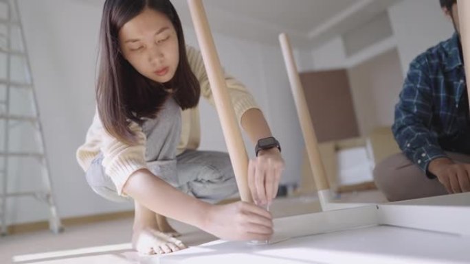 亚洲妇女转动六角扳手到DIY桌上的紧固螺栓