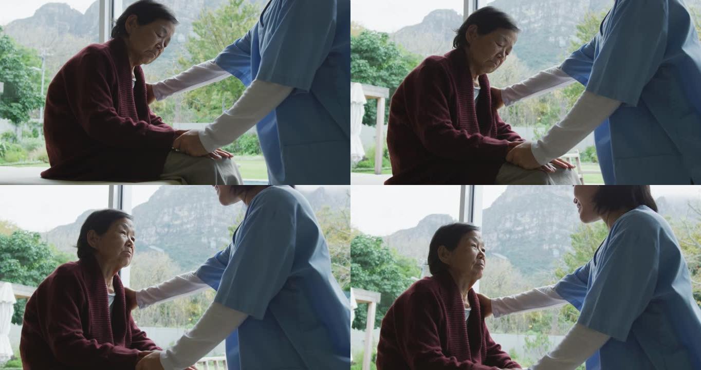 微笑的亚洲女医生安慰资深女病人并在手术中交谈
