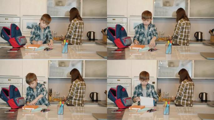 小学生在照顾母亲在厨房做饭的同时做作业