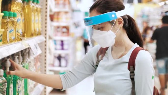 亚洲女子在超级市场购物时戴防护口罩