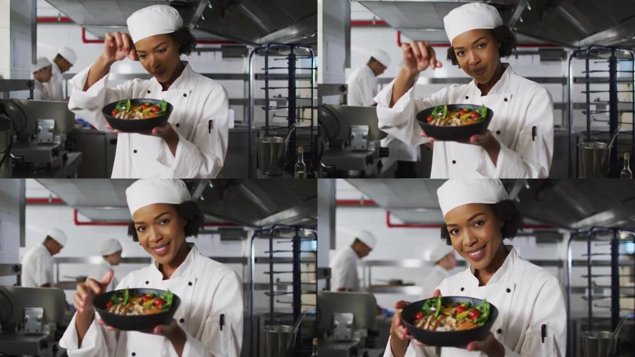 非裔美国女厨师装饰菜肴并看着相机的肖像