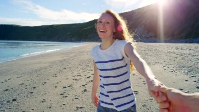 4k视频片段，一名年轻女子将男友带到海滩