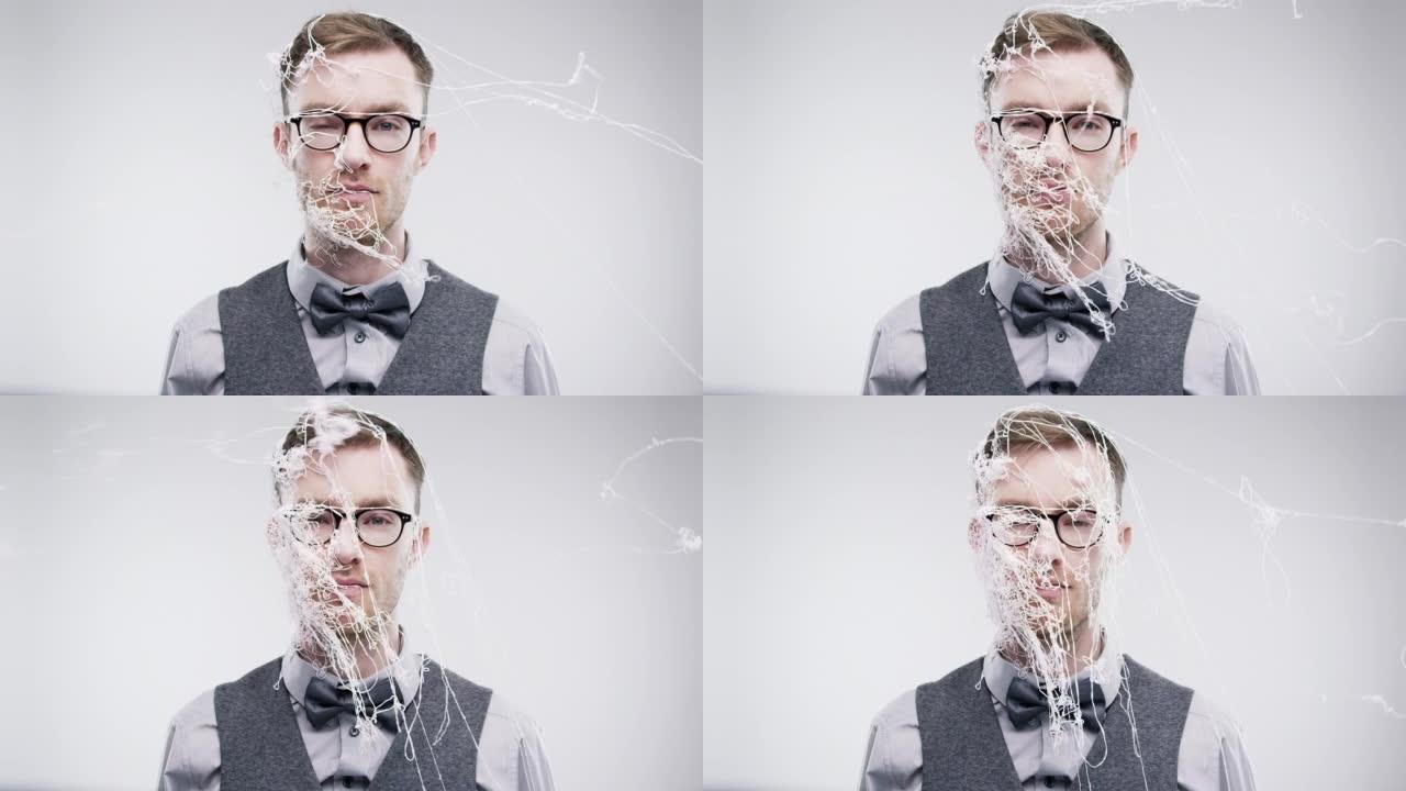 4k视频片段，一个年轻人在工作室背景下用五彩纸屑喷在脸上