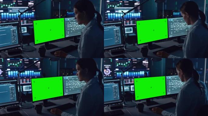 在现代监控办公室工作的女软件工程师，计算机显示屏上的绿屏模型。监控室大数据科学家和管理人员坐在电脑前