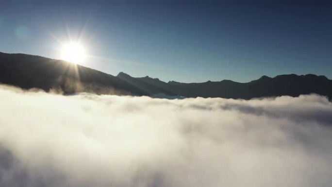 飞越云层云雾缭绕逆光光芒山区轮廓