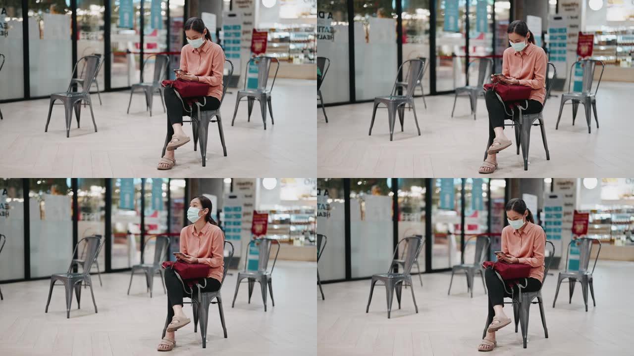 亚洲妇女坐在社交距离的椅子上等待餐厅