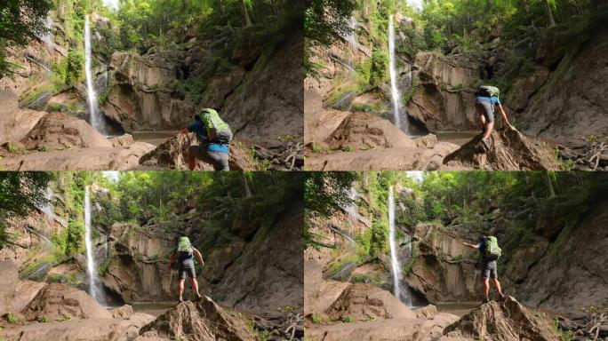 雄性徒步旅行者在雨林中徒步旅行在绿色森林中的小溪瀑布探险