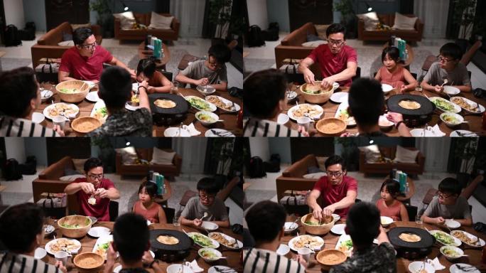 亚洲华人家庭和朋友在家里吃晚餐，吃传统的中国汽船菜肴