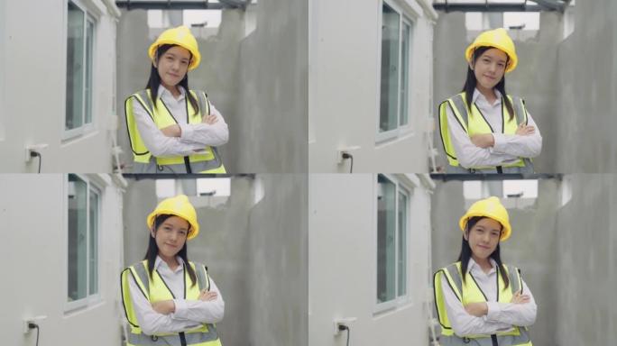 亚洲女性工程师的肖像在建筑工地上站着双臂交叉