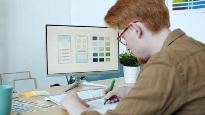 创意青年着色移动应用草稿看电脑屏幕在办公室工作