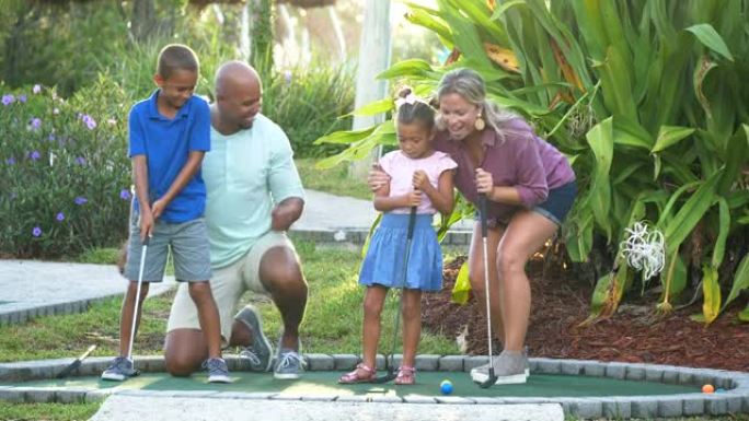 跨种族家庭，两个孩子打迷你高尔夫