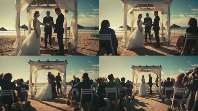 美丽的新娘和新郎在海边的户外婚礼上。浪漫情侣结婚、交换戒指、亲吻和与多民族朋友分享庆祝活动的完美场所