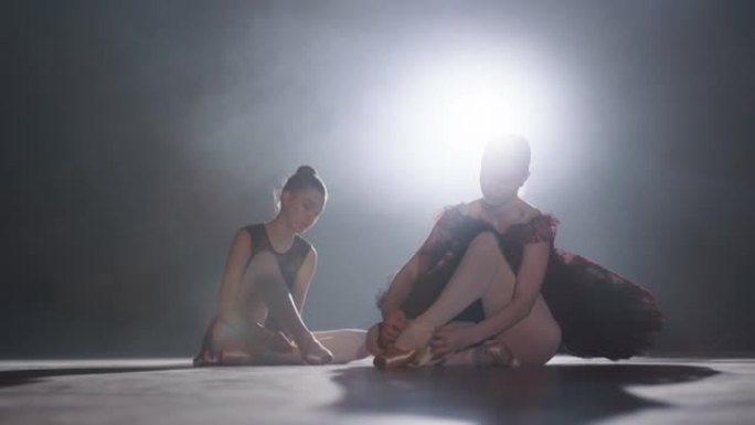 SLO MO两名芭蕾舞演员在舞台上系芭蕾舞鞋