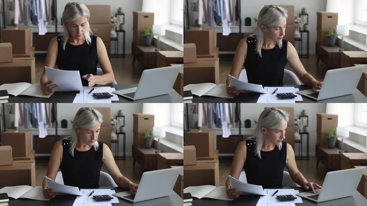 成熟的女性时装设计师坐在办公桌前做会计工作