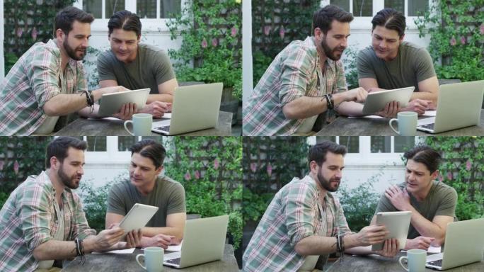 两个英俊的年轻商人在后院外面工作的4k录像