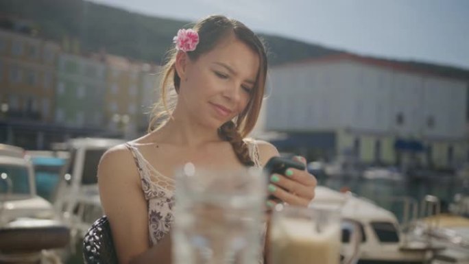 年轻女子坐在餐厅时使用手机发短信