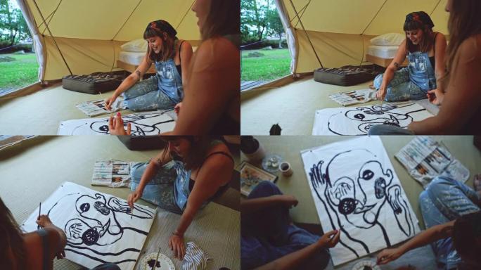 两名年轻女子在大自然帐篷内的纸上画画
