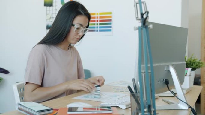 亚洲女性的慢动作肖像应用程序开发人员设计应用程序界面在办公室工作