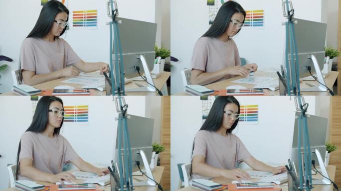 亚洲女性的慢动作肖像应用程序开发人员设计应用程序界面在办公室工作